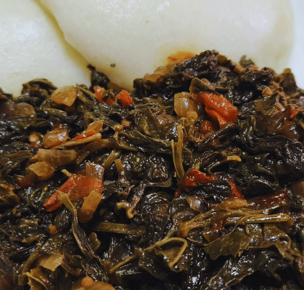Venda mukusule dried green leafy vegetable simmering in pot with onions and oil